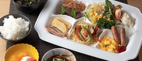 A meal with various dishes including rice, noodles, and vegetables.