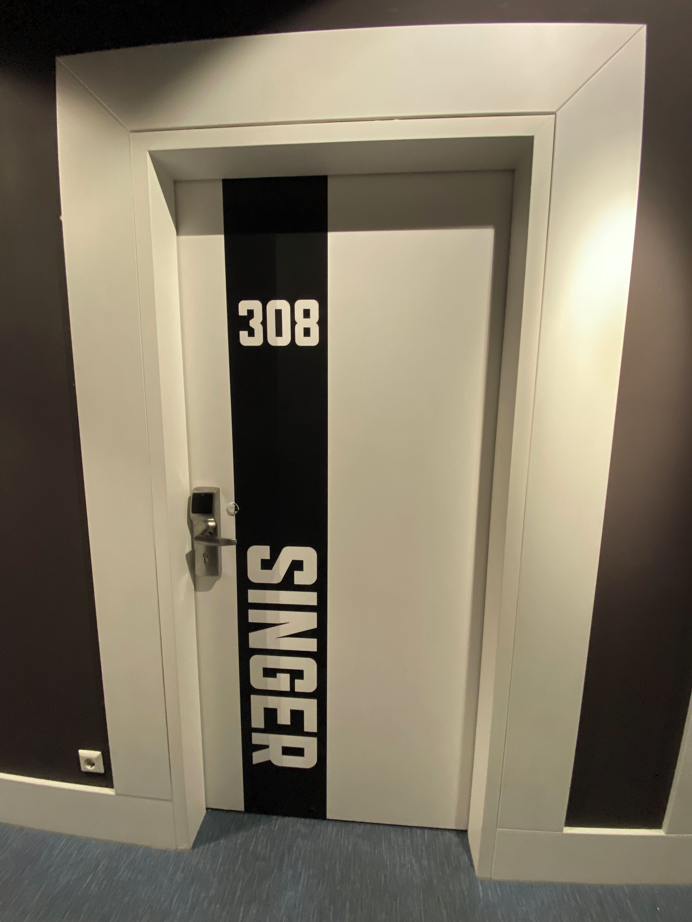 Eine Tür mit der Nummer 308 und dem Schriftzug SINGER.