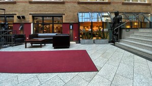 A spacious lobby with a red carpet, seating area, and a staircase leading to an upper floor. - Singer109 Hostel (Berlin)