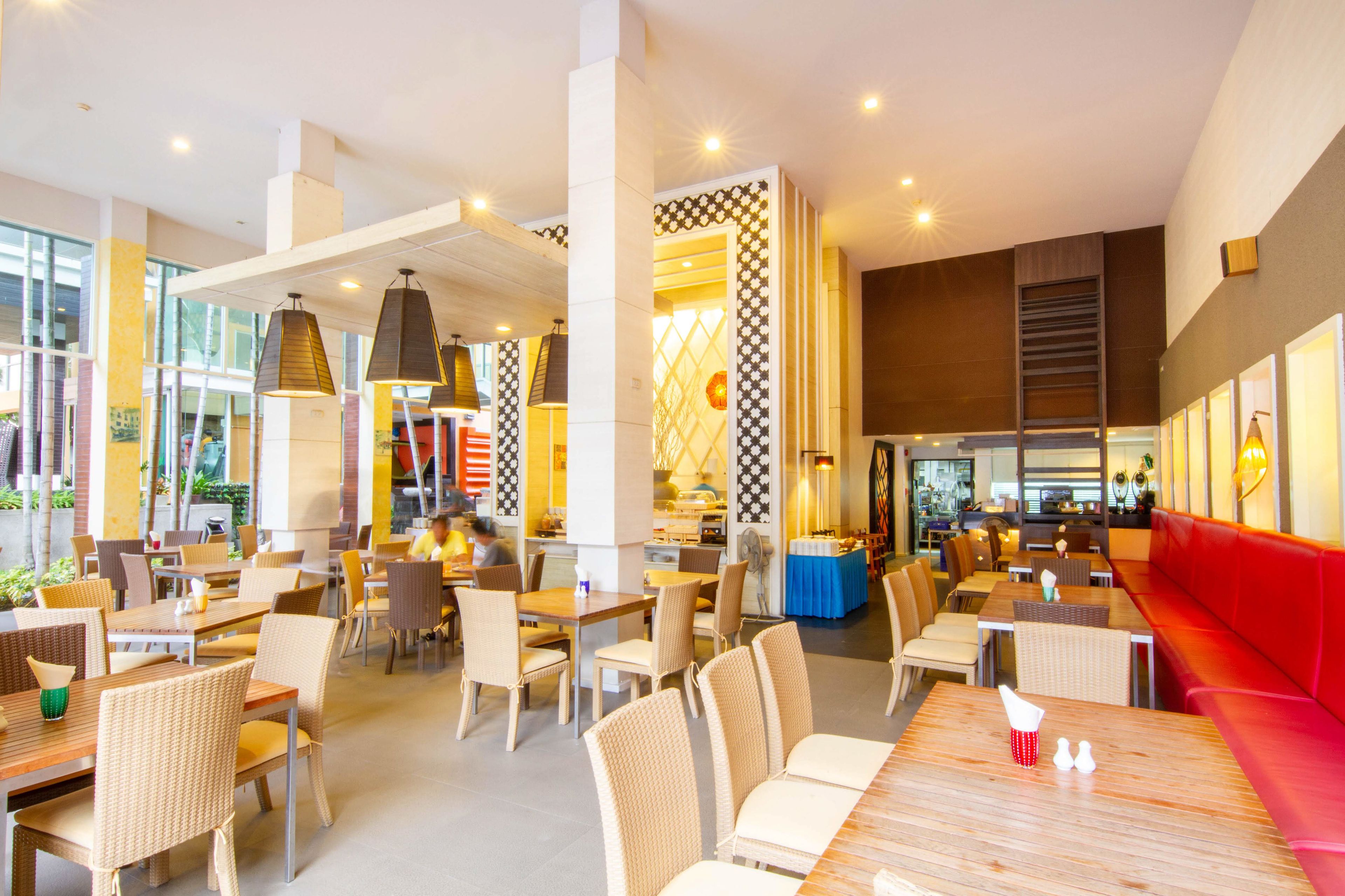 A spacious restaurant with high ceilings, modern lighting, and a mix of seating arrangements including tables and booths.