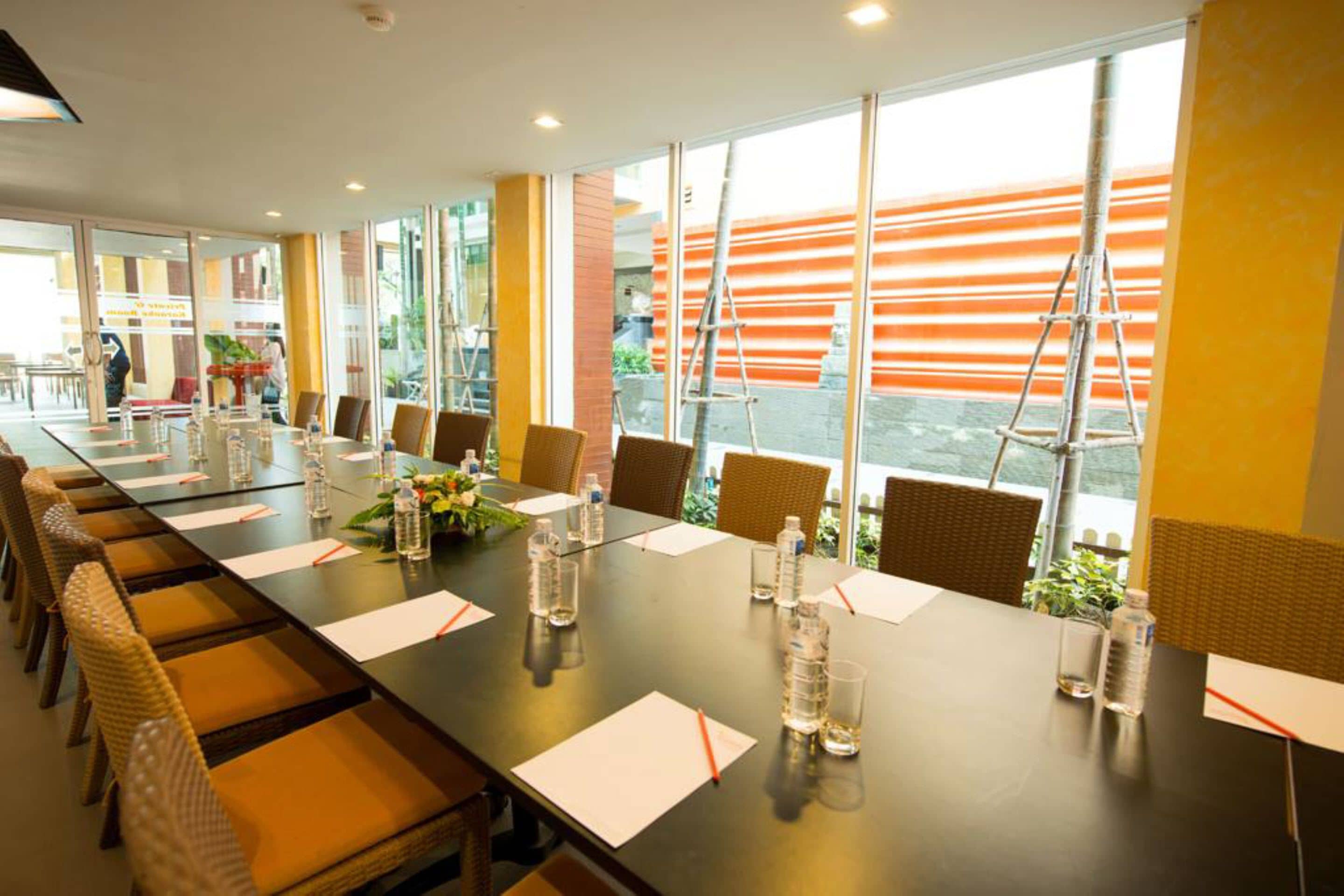 A conference room with a long table, chairs, and water bottles.