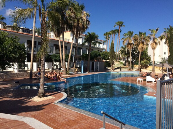 Een seizoensgebonden buitenzwembad, parasols voor strand/zwembad