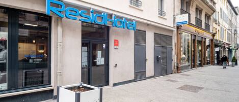 A hotel named ResidHotel with a modern facade, large windows, and a visible entrance.