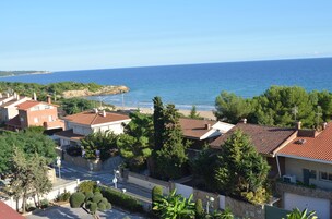 Una zona residenziale sul lungomare, con case, vista chiara sul mare e una strada che conduce alla spiaggia.