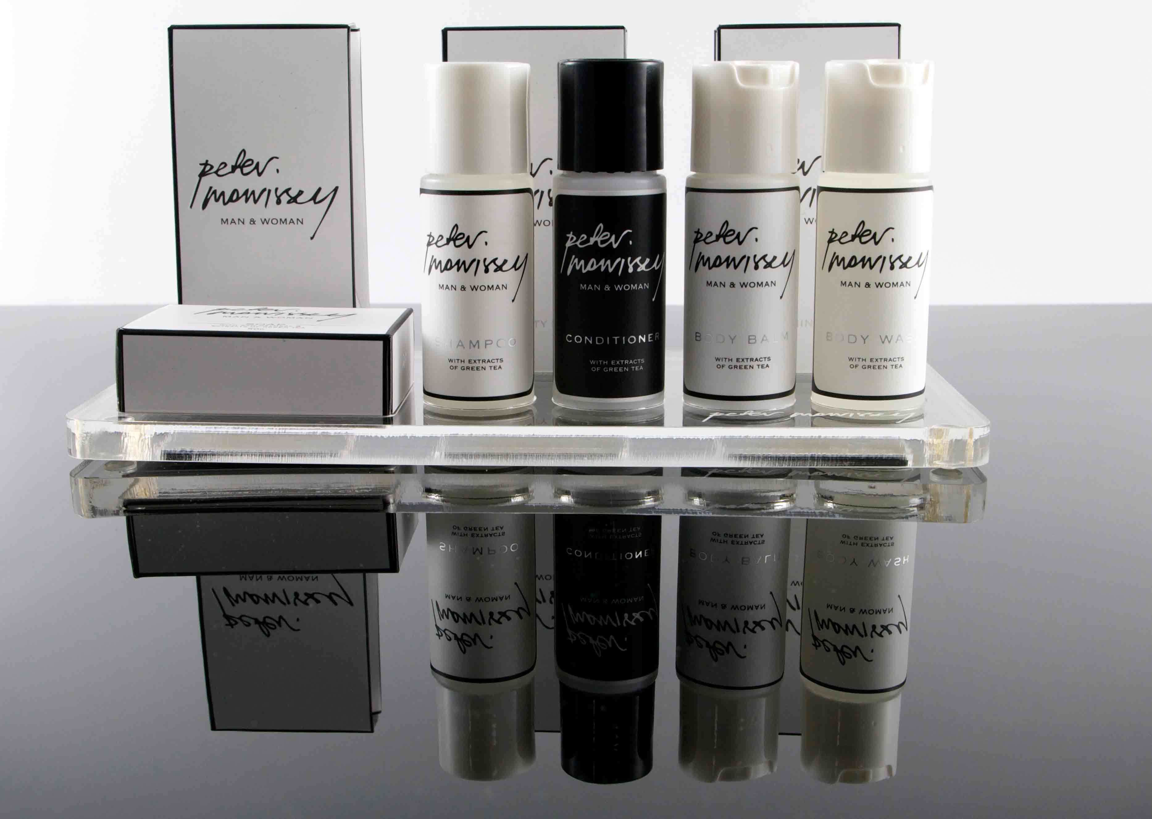 A collection of Peter & Mowissey products including shampoo, conditioner, body balm, and body wash, all with extracts of green tea.