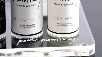 Three bottles of 'Peter Mawissel' body balm on a reflective surface.