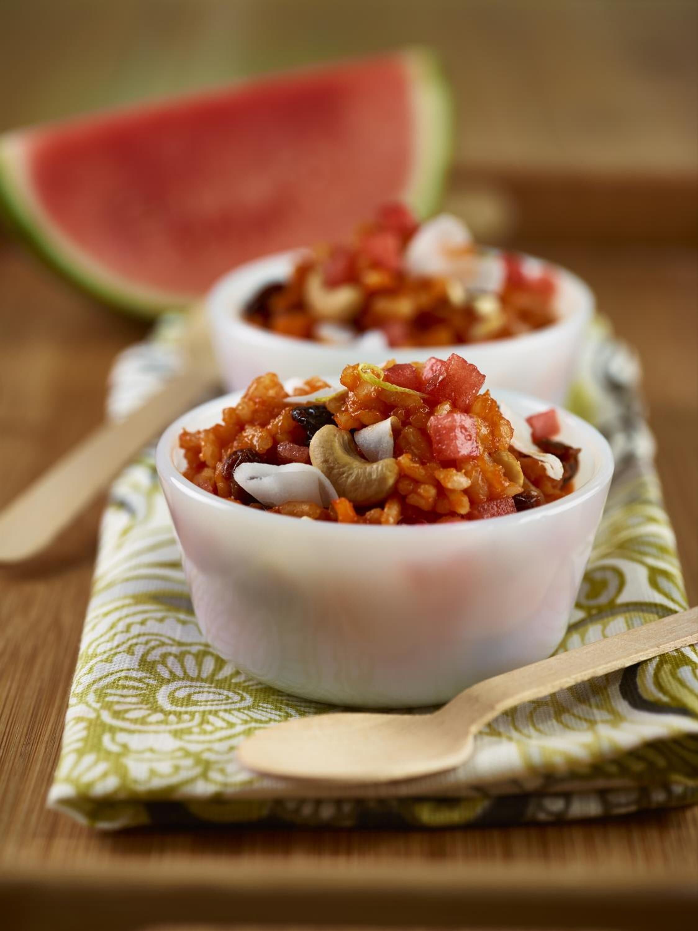 Two bowls of food on a wooden table with a green patterned cloth underneath.