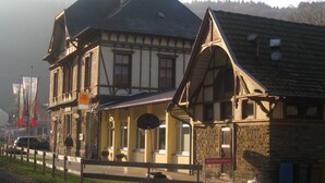 Un edificio tradizionale con struttura a graticcio, facciata in pietra, un balcone e una insegna che indica un ristorante.