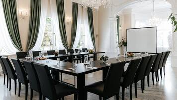 A conference room with a long table, black chairs, and a whiteboard.