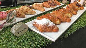 A variety of pastries on a white plate with a label "Brioche" on a wooden block.