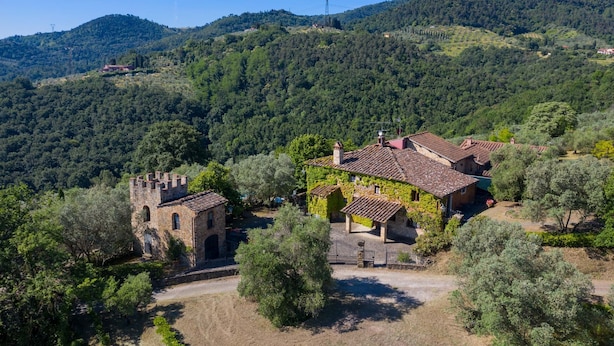 A rural villa with a stone tower, surrounded by olive trees and hills. - Relais Colline San Biagio (Carmignano)