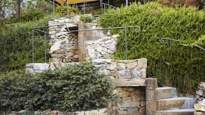 A stone staircase leading to a covered outdoor area with a yellow canopy. - Relais Colline San Biagio (Carmignano)