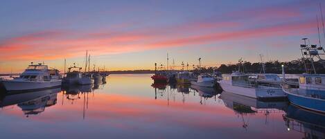 Un puerto deportivo con barcos amarrados al atardecer.