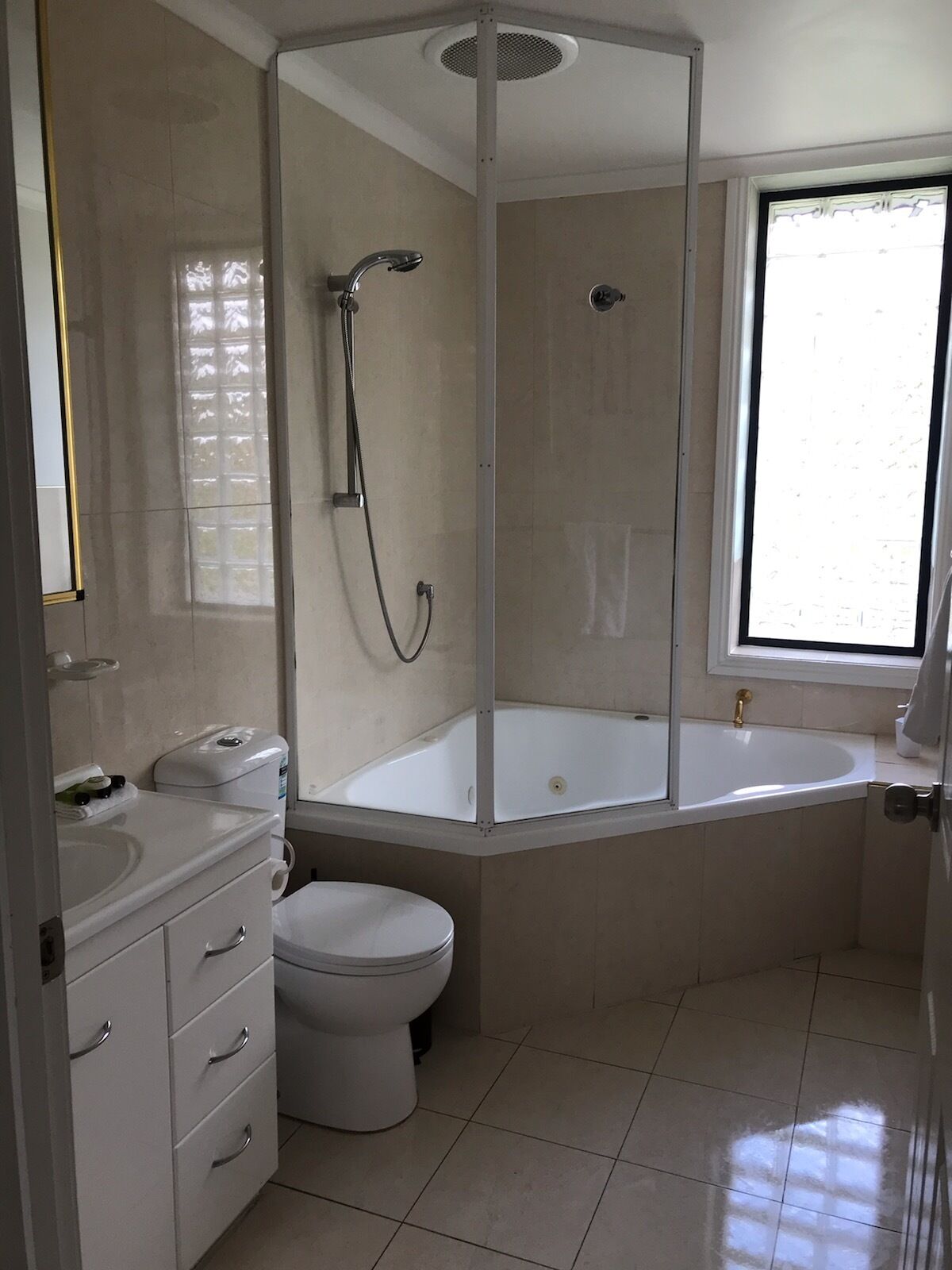 Un baño moderno con cabina de ducha, bañera, inodoro y lavabo.