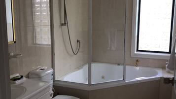 Un baño moderno con cabina de ducha, bañera, inodoro y lavabo.