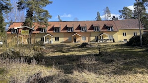 Un bâtiment à deux étages, doté d’un toit recouvert de tuiles rouges, de nombreuses fenêtres et d’un petit porche.