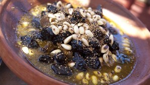 A bowl of mixed nuts and dried fruits in a rustic setting. - Dar KamalChaoui (Bhalil)