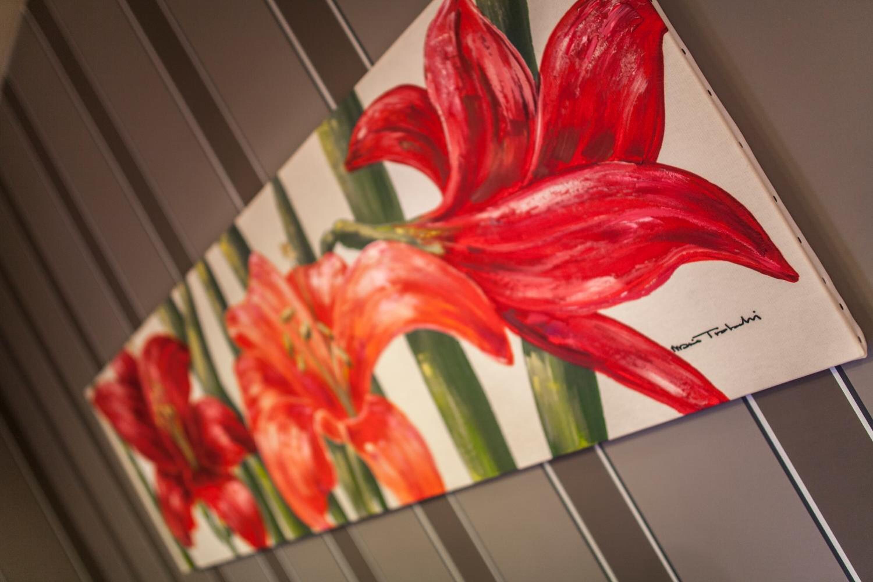 A painting of red flowers on a wall.
