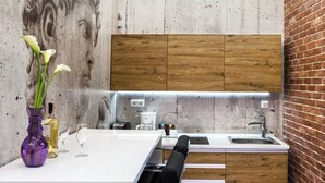 Une cuisine moderne dotée d’un îlot central, de meubles en bois et d’un mur d’accent en briques.