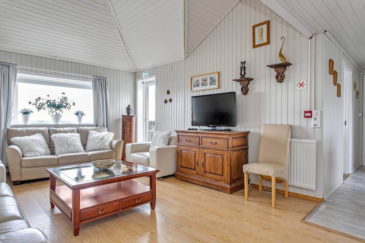 A living room with a sofa, coffee table, TV, and decorative items.