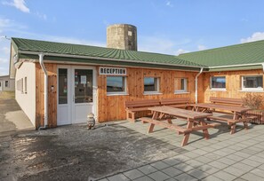 A wooden reception building with a green roof and a sign labeled "RECEPTION".