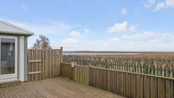 Une terrasse en bois offrant une vue sur une plage et des marais.