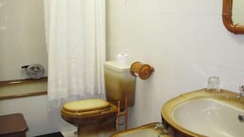 Ein Badezimmer mit Toilette, Bidet, Waschbecken und Spiegel.