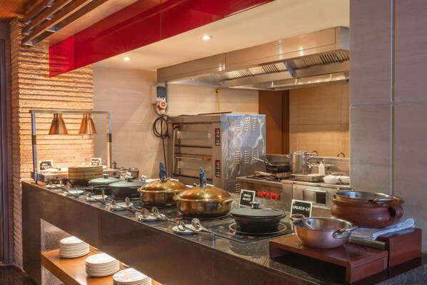Una mesa de buffet con diversos alimentos y utensilios para servir.