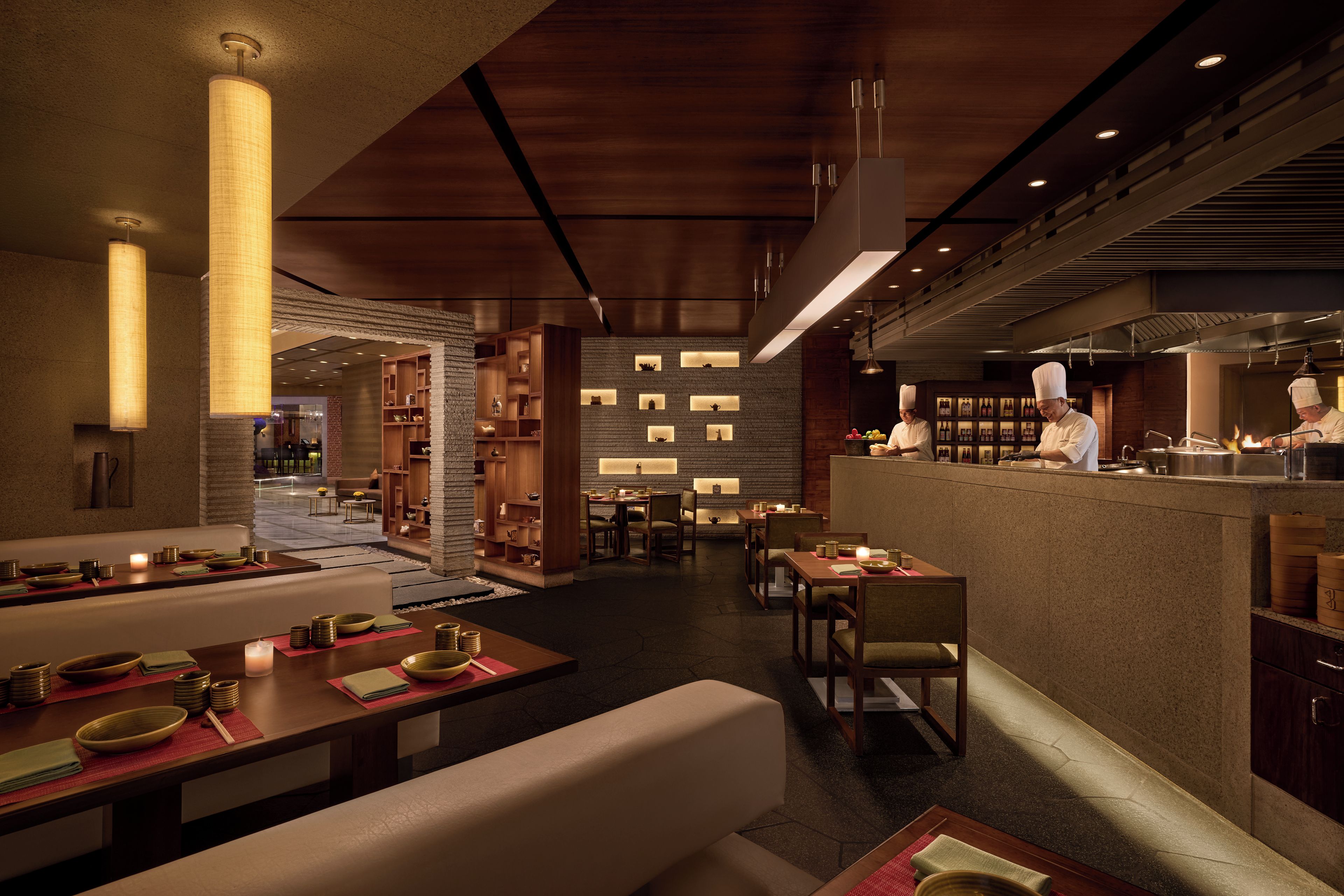 A restaurant interior with dining tables, chairs, and a bar area.