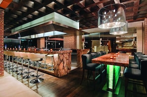 A bar area with multiple stools, a marble counter, and a dining table with chairs.