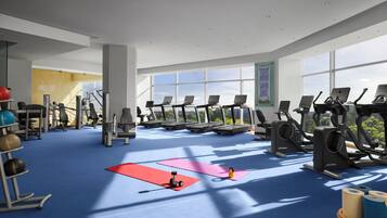 Un gimnasio con cintas de correr, pelotas de ejercicio y máquinas de pesas.