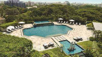 Relax by the pool surrounded by lush greenery and modern architecture.