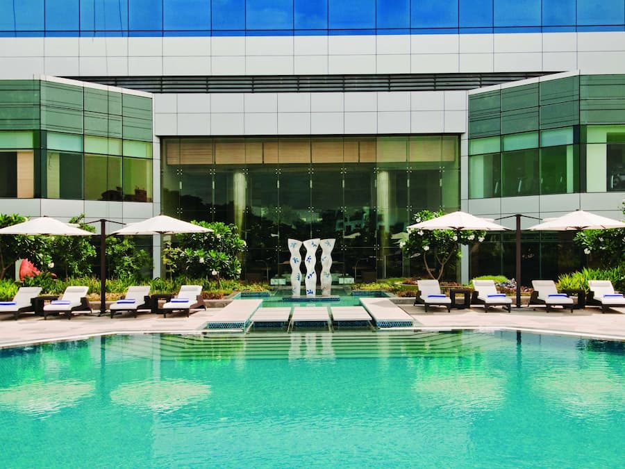 Una piscina al aire libre, sillones reclinables de piscina