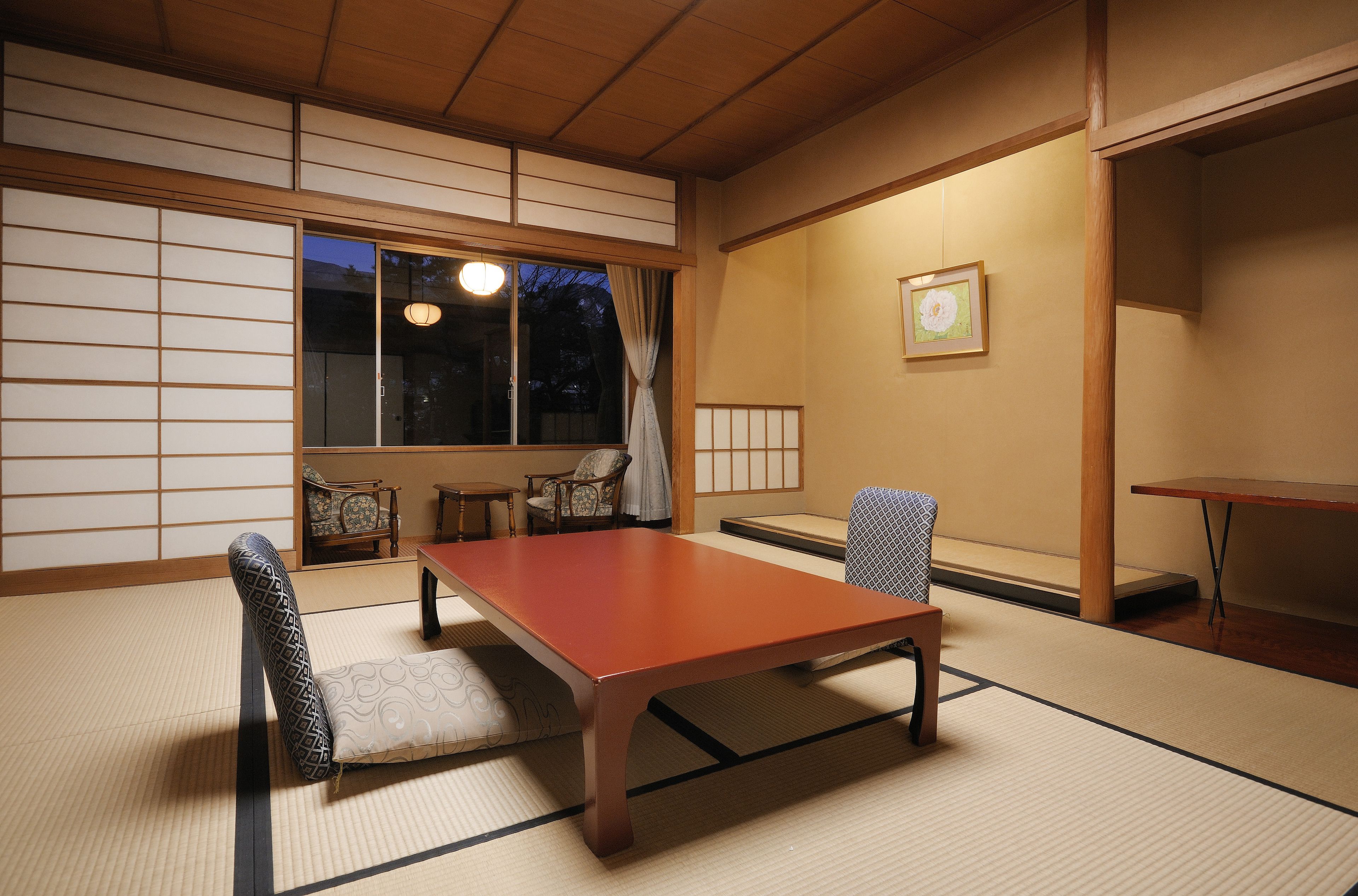 Una habitación japonesa tradicional con suelo de tatami, una baja mesa de madera y un sofá de tatami.