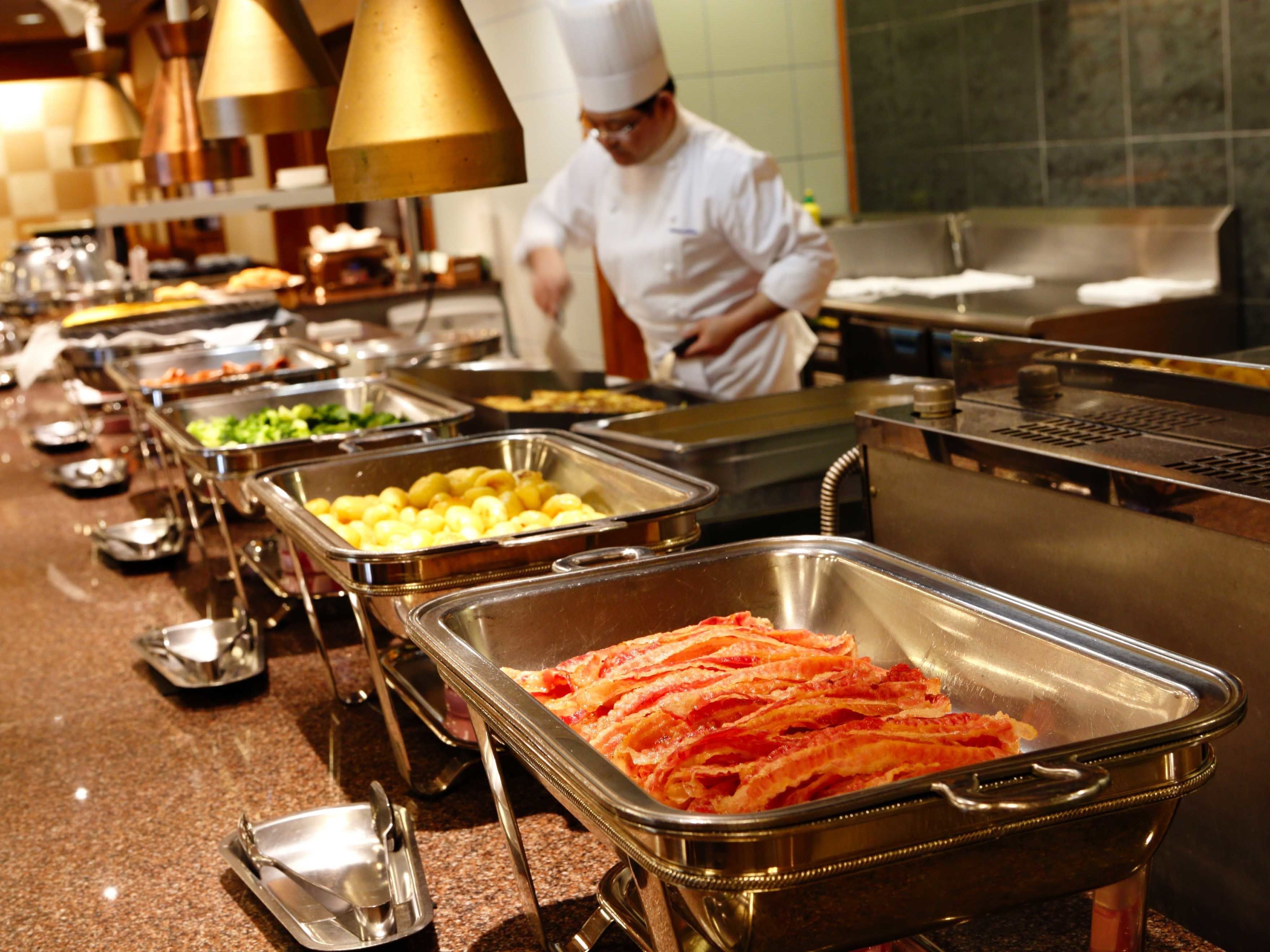 A buffet setup with various food items in metal containers.