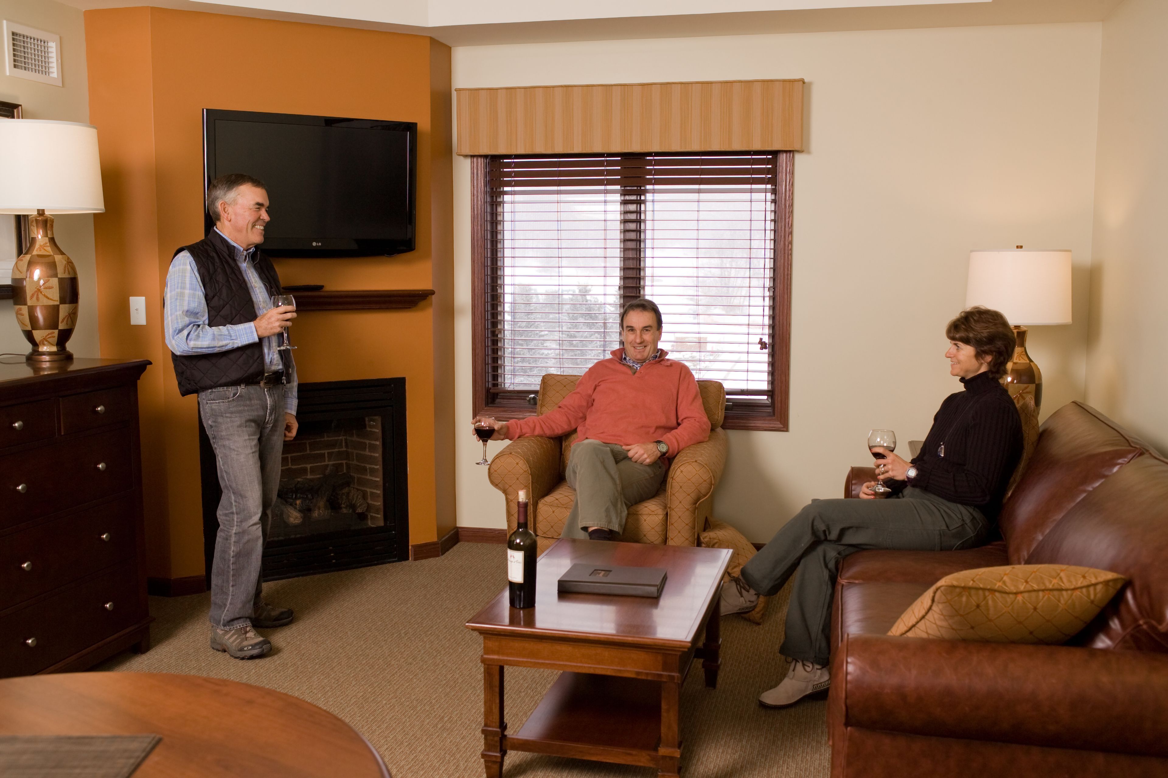A living room with a fireplace, a television, and a coffee table.