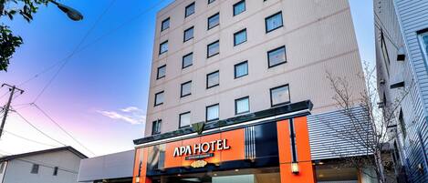 A hotel with a modern facade, multiple windows, and a prominent entrance with a sign.