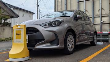 A car parked next to a yellow sign with the Times Car logo.