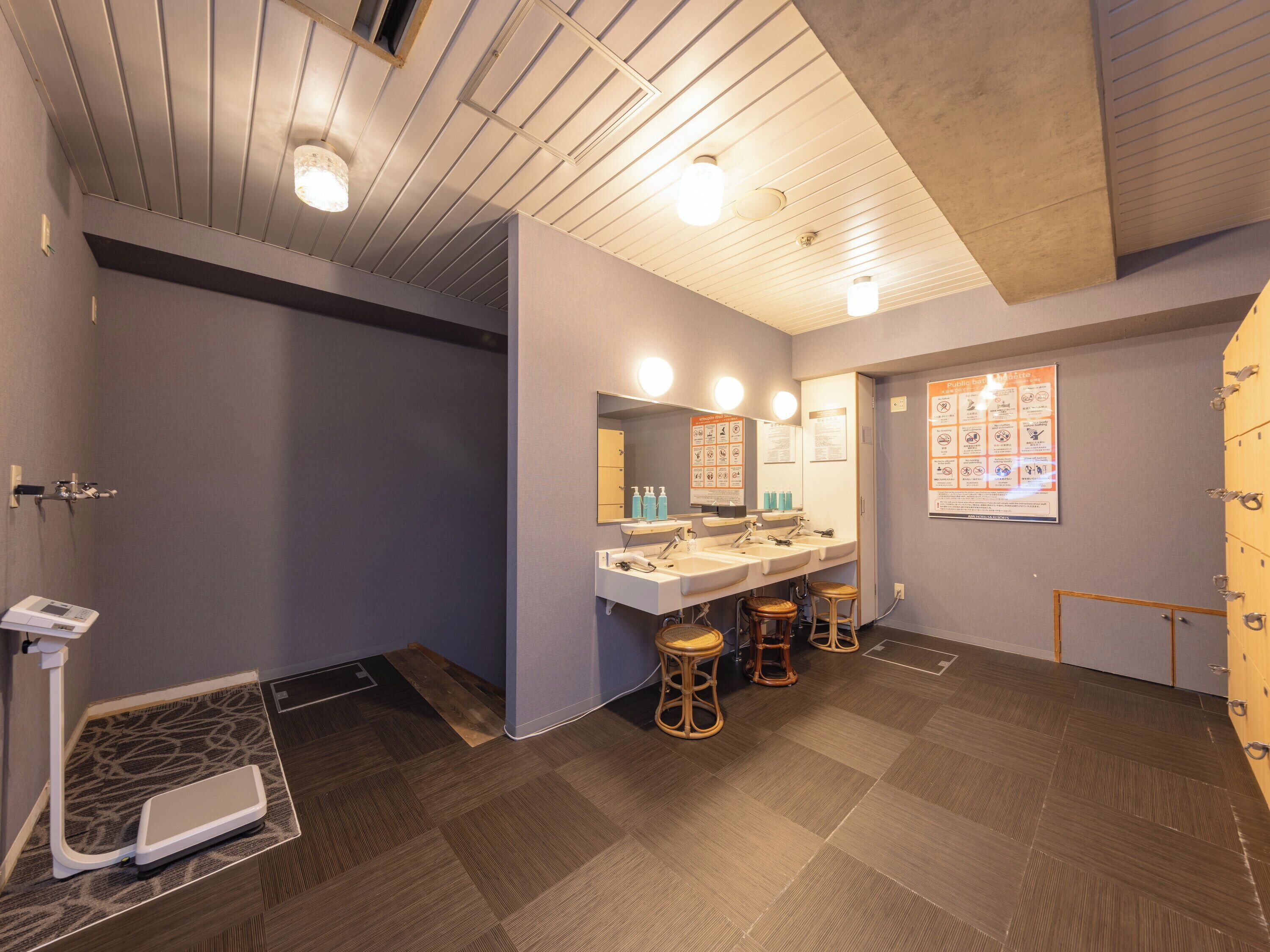 Un baño moderno con un espejo grande, tres lavamanos y un mueble de tocador de madera.