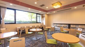 A conference room with multiple tables and chairs, large windows with curtains, and a chandelier. - APA Hotel Kitakami Ekinishi (Kitakami)