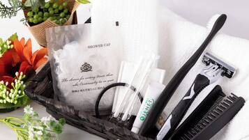 A bathroom vanity with a white towel, a black comb, a white toothbrush, and a shower cap.