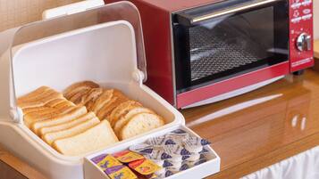 A toaster and a microwave on a wooden table.