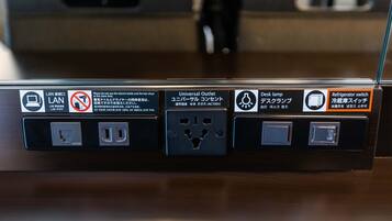 A power outlet with a universal outlet adapter, a desk lamp, and a refrigerator switch.