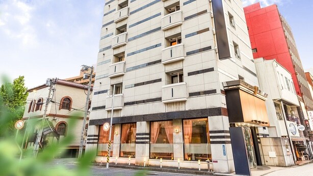 Ein mehrstöckiges Hotel mit moderner Fassade, großen Fenstern und einem markanten Eingangsbereich mit Überdachung.