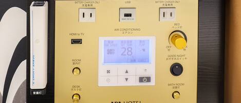 A control panel with a digital display, USB port, and various buttons for room and desk lighting, air conditioning, and a good night mode.