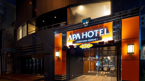 Exterior del hotel APA, con una entrada destacada y un cartel que muestra el número 156.