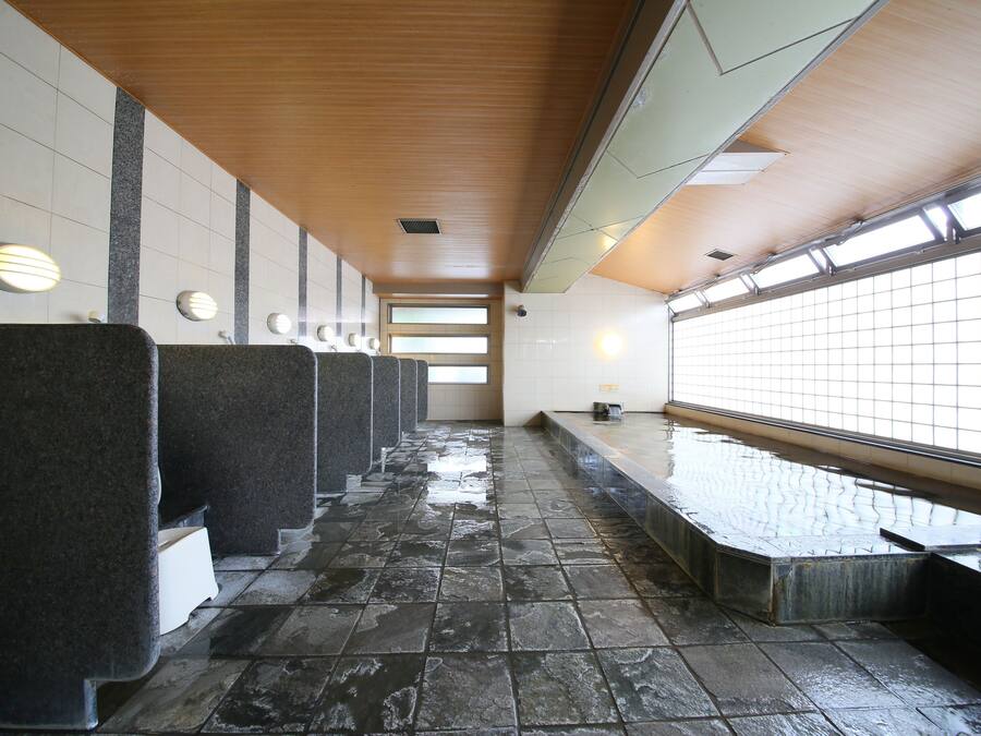A public restroom with multiple sinks, tiled walls, and a wooden ceiling.