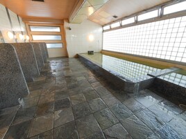 A public restroom with granite counters, a tiled floor, and a windowed wall.