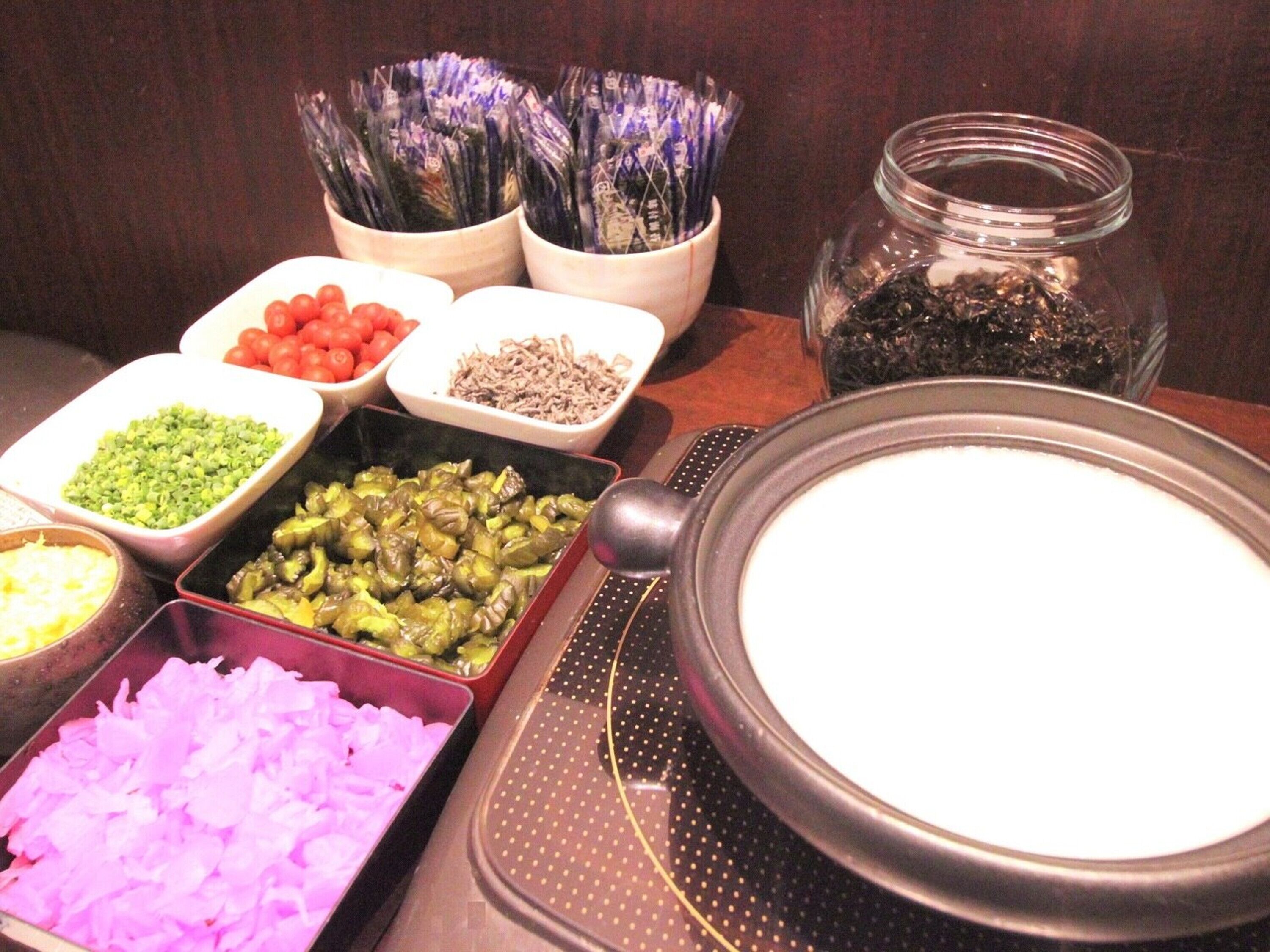 Een buffet met diverse gerechten, waaronder gesneden groenten en kruiden.