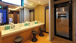 Une salle de bain moderne avec un grand miroir, deux vasques et un porte-serviettes.